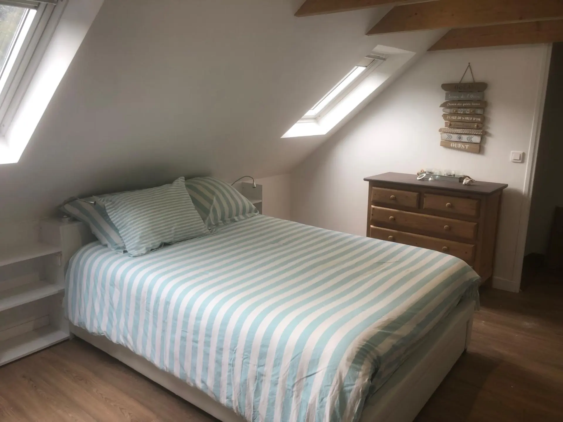 Chambre avec lit double et commode en bois