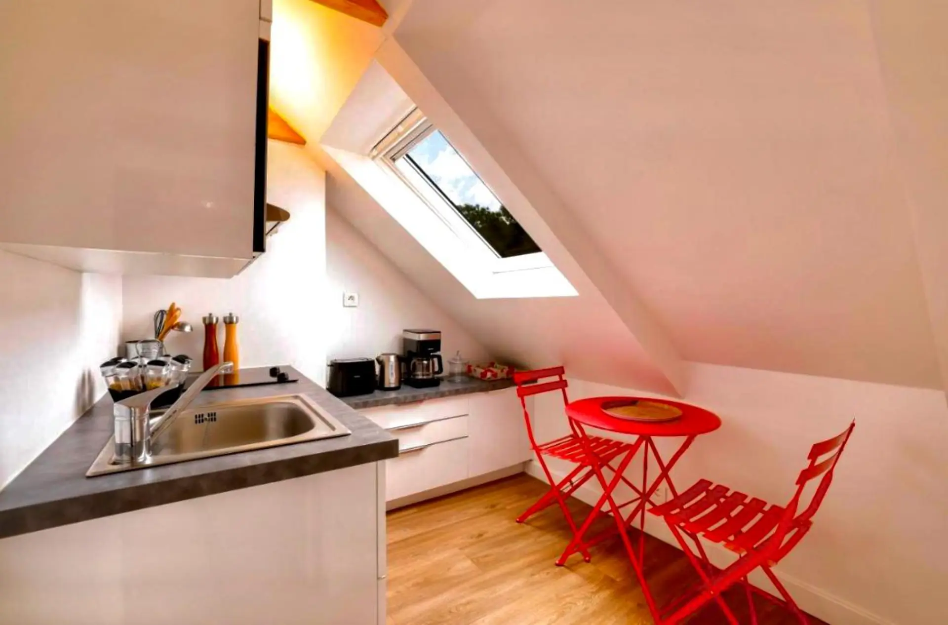 Kitchenette avec velux et table bistrot rouge