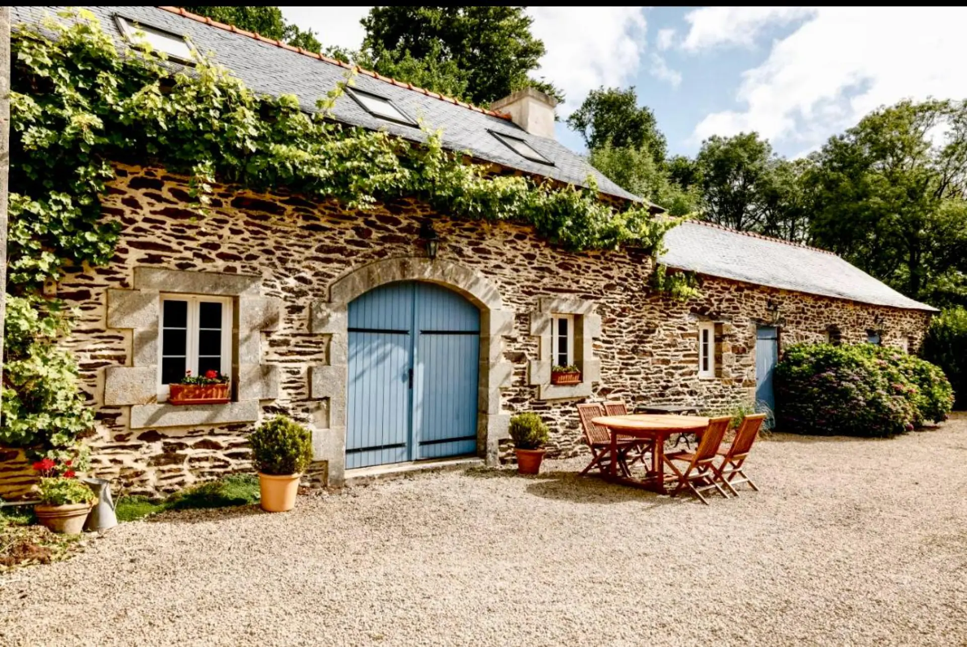 Façade en pierre bretonne avec porte bleue