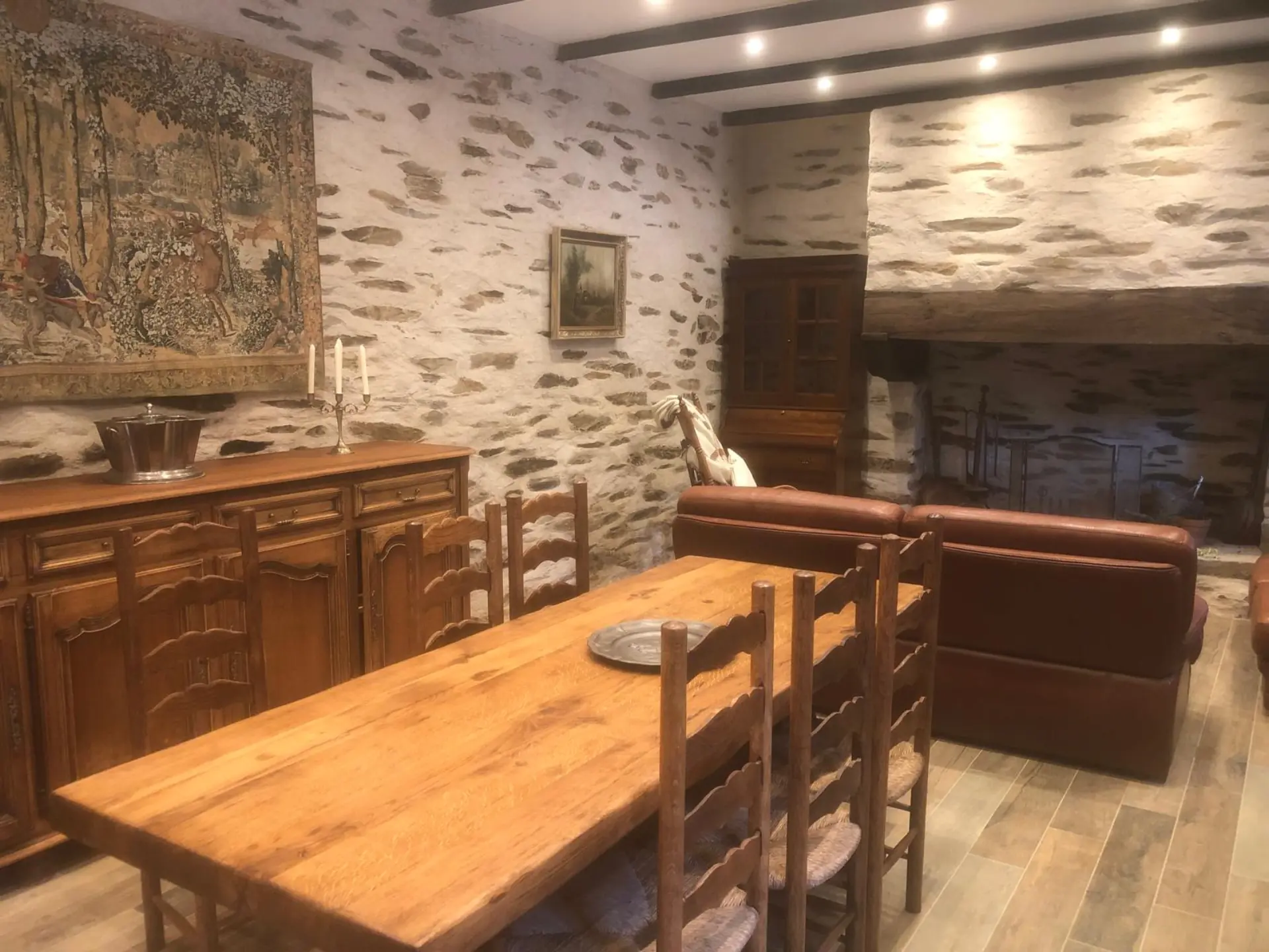 Salle à manger avec table en bois massif et murs en pierre